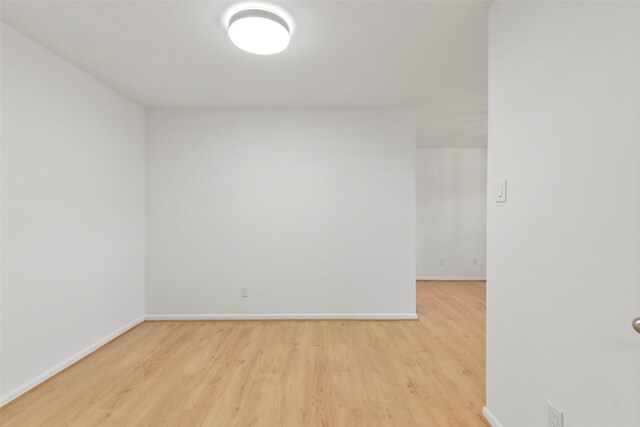 spare room featuring wood finished floors and baseboards