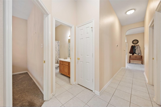 14402 Eastern Redbud Ln, Houston, TX 77044 - corridor featuring light tile patterned flooring, arched walkways, and baseboards