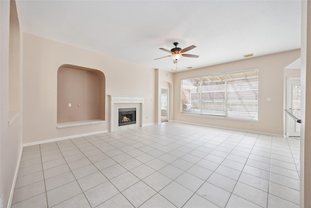 14402 Eastern Redbud Ln, Houston, TX 77044 - unfurnished living room with a ceiling fan, light tile patterned floors, a tile fireplace, and baseboards