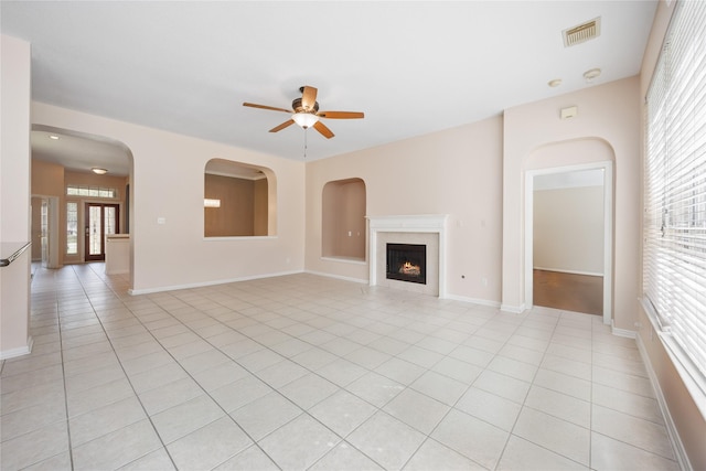 14402 Eastern Redbud Ln, Houston, TX 77044 - unfurnished living room with a ceiling fan, a warm lit fireplace, light tile patterned floors, and baseboards