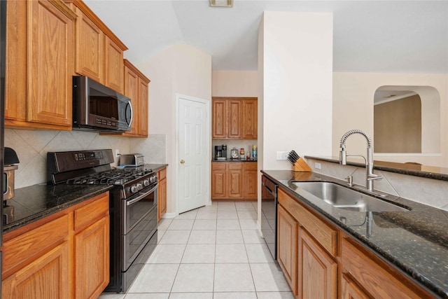 14402 Eastern Redbud Ln, Houston, TX 77044 - kitchen featuring stainless steel appliances, a sink, dark stone counters, backsplash, and light tile patterned floors