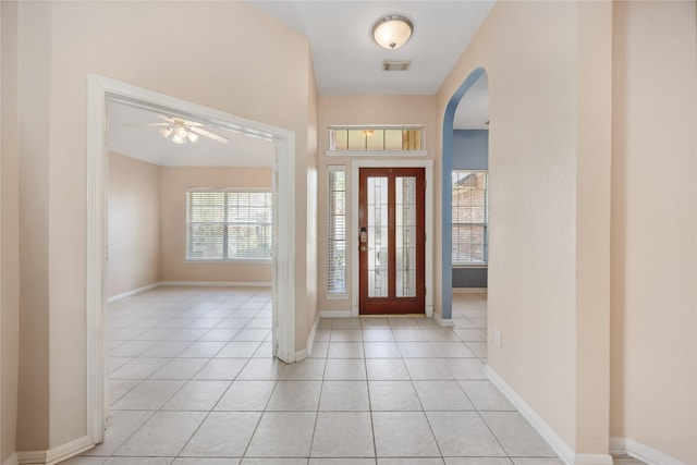 14402 Eastern Redbud Ln, Houston, TX 77044 - entrance foyer with arched walkways, ceiling fan, light tile patterned floors, and baseboards