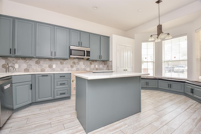 1049 Misty Clf, Dickinson, TX 77539 - kitchen featuring appliances with stainless steel finishes, light wood finished floors, a chandelier, and tasteful backsplash