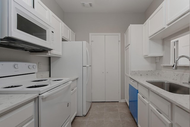 3500 Tangle Brush Dr Unit 217, The Woodlands, TX 77381 - kitchen featuring white appliances, a sink, white cabinetry, light tile patterned floors, and light stone counters