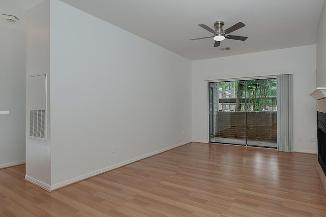 3500 Tangle Brush Dr Unit 217, The Woodlands, TX 77381 - spare room featuring light wood-type flooring, a fireplace, a ceiling fan, baseboards, and a smoke detector
