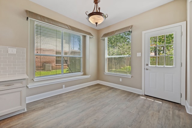unfurnished dining area featuring light wood-style floors and baseboards