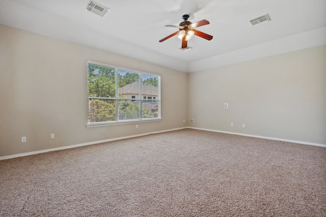carpeted spare room featuring ceiling fan and baseboards
