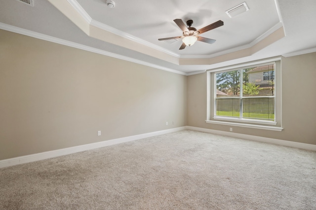 unfurnished room with a raised ceiling, ceiling fan, crown molding, light colored carpet, and baseboards