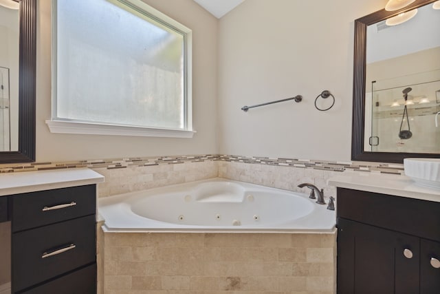 bathroom featuring vanity, a whirlpool tub, and a stall shower