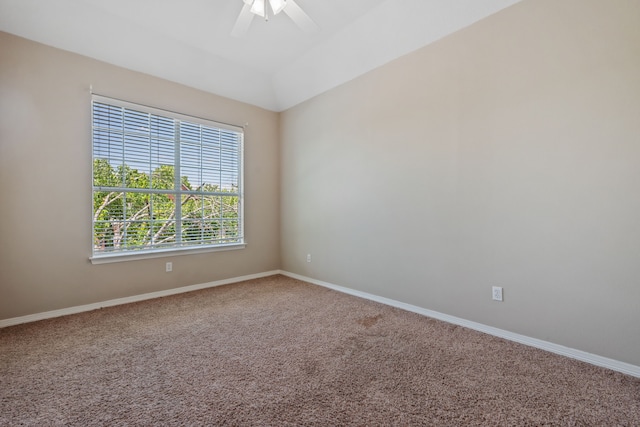 empty room featuring carpet flooring, baseboards, ceiling fan, and lofted ceiling