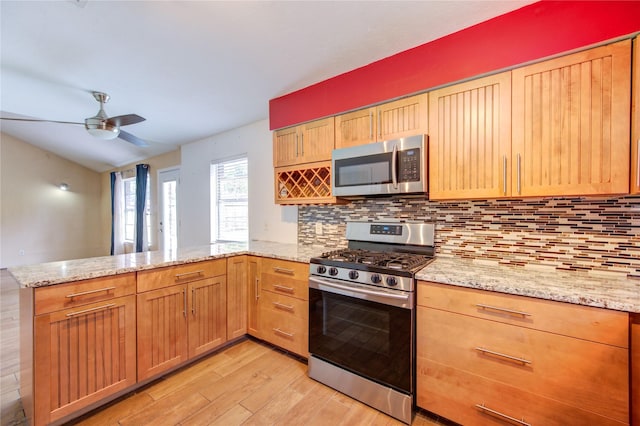 3711 Clover Meadows St, Pasadena, TX 77505 - kitchen with appliances with stainless steel finishes, a peninsula, light wood finished floors, backsplash, and ceiling fan