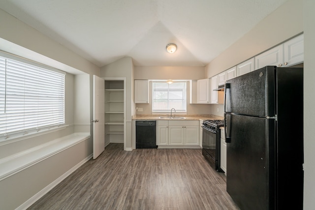 kitchen with black appliances, a sink, wood finished floors, white cabinets, and lofted ceiling