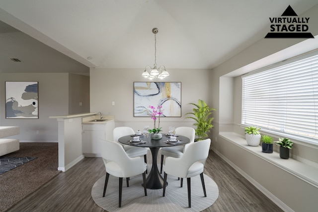 dining room featuring wood finished floors, baseboards, vaulted ceiling, and a chandelier