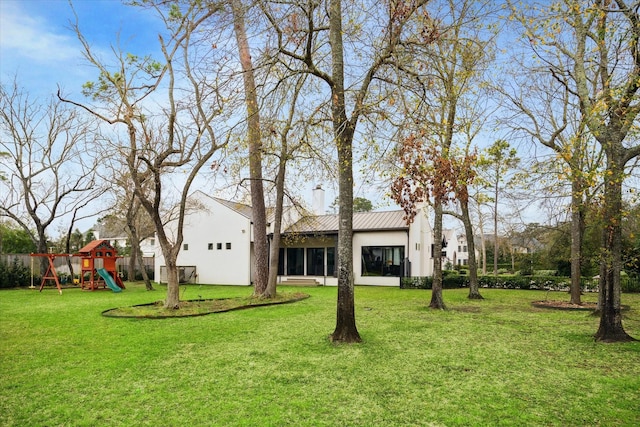view of yard with a playground and a sunroom