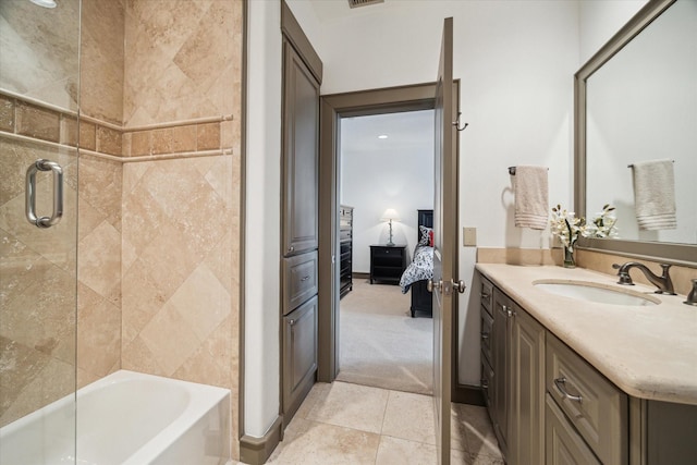 ensuite bathroom with vanity, tile patterned floors, and bath / shower combo with glass door