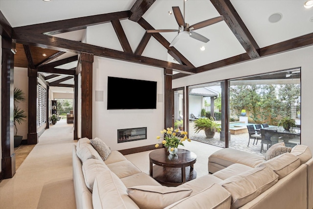 living area with beamed ceiling, ceiling fan, high vaulted ceiling, recessed lighting, and a glass covered fireplace