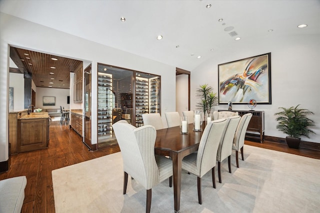dining room featuring dark wood-style floors, recessed lighting, and vaulted ceiling