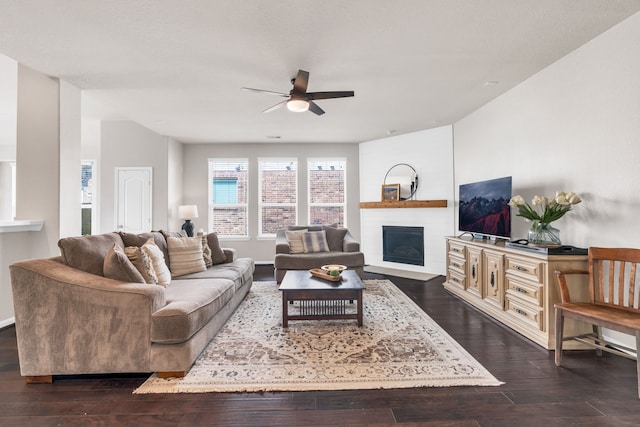 9962 Ash Creek Ct, Brookshire, TX 77423 - living room featuring a ceiling fan, a fireplace with flush hearth, dark wood-style flooring, and baseboards