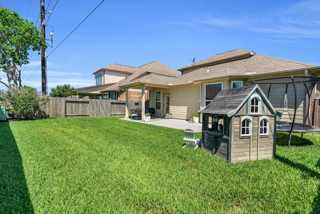 9962 Ash Creek Ct, Brookshire, TX 77423 - rear view of house featuring a trampoline, a patio, an outdoor structure, and a storage unit