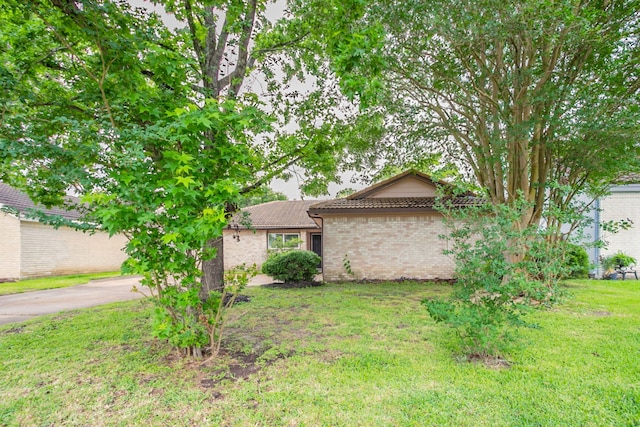 5935 Caruso Forest Dr, Houston, TX 77088 - view of front of home featuring a front lawn, brick siding, and a tiled roof