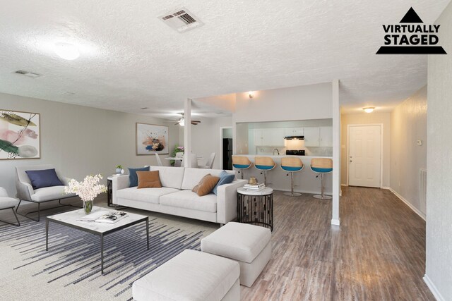 5935 Caruso Forest Dr, Houston, TX 77088 - living room featuring wood finished floors, a textured ceiling, baseboards, and ceiling fan