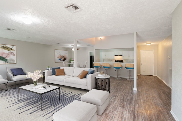 5935 Caruso Forest Dr, Houston, TX 77088 - living room with wood finished floors, a textured ceiling, baseboards, and ceiling fan