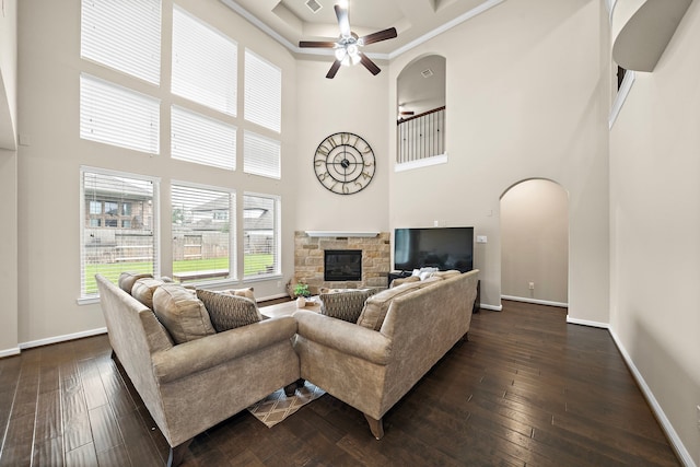 27916 Seger Bend Trl, Spring, TX 77386 - living area featuring a towering ceiling, ceiling fan, arched walkways, a fireplace, and baseboards