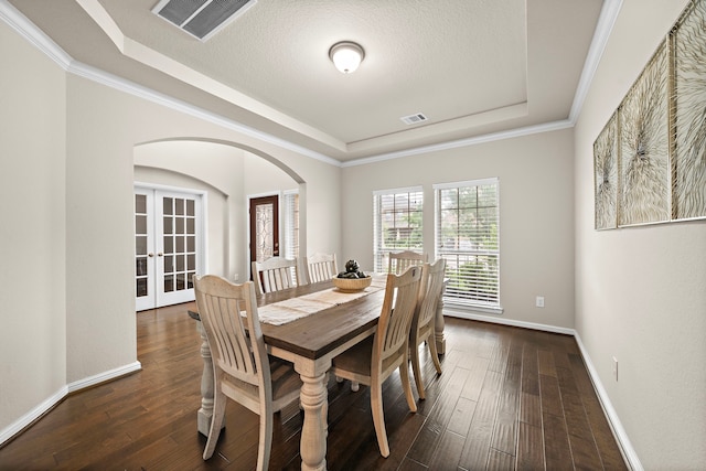 27916 Seger Bend Trl, Spring, TX 77386 - dining area featuring a raised ceiling, arched walkways, french doors, baseboards, and dark wood-style floors