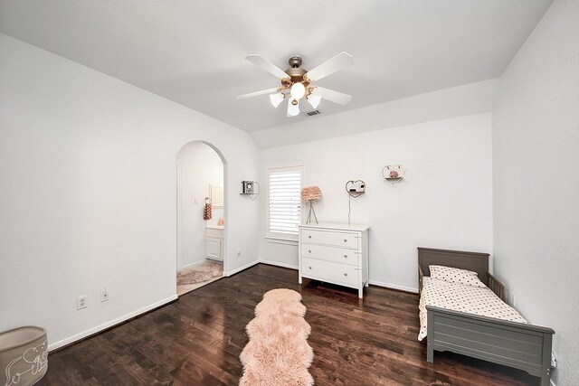 bedroom featuring arched walkways, baseboards, wood finished floors, and ceiling fan
