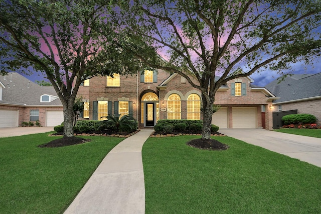 traditional home featuring brick siding, concrete driveway, and a front yard