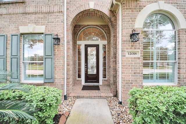 view of exterior entry with brick siding
