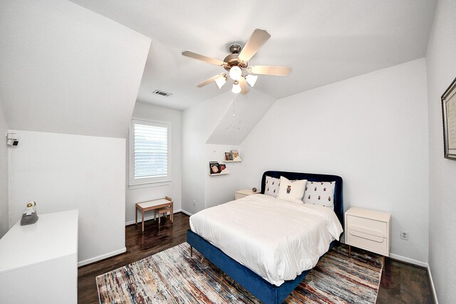 bedroom featuring wood finished floors, lofted ceiling, baseboards, and a ceiling fan
