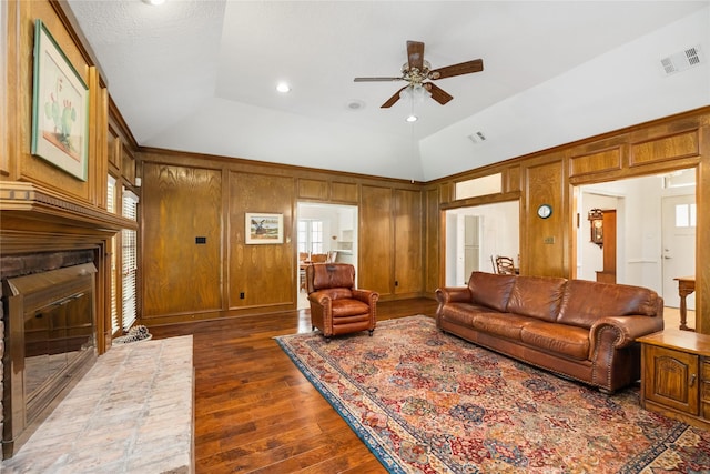 12915 Lake Mist Dr, Cypress, TX 77429 - living room featuring a ceiling fan, a fireplace, dark wood-type flooring, vaulted ceiling, and wood walls