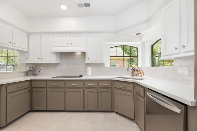 12915 Lake Mist Dr, Cypress, TX 77429 - kitchen with stainless steel dishwasher, a sink, white cabinetry, and decorative backsplash