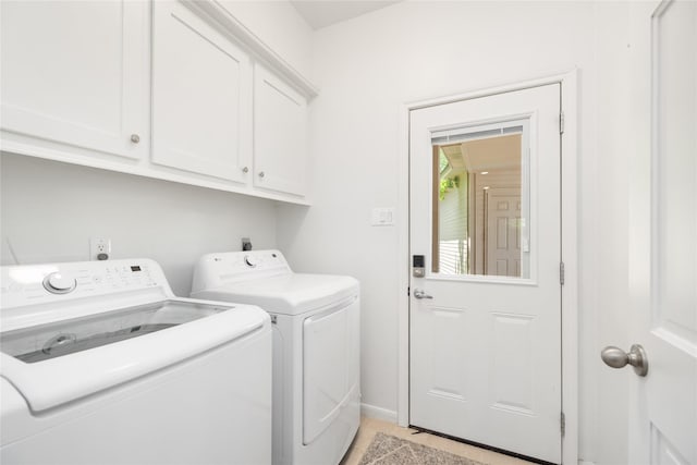 12915 Lake Mist Dr, Cypress, TX 77429 - clothes washing area with washer and dryer, cabinet space, light tile patterned floors, and baseboards