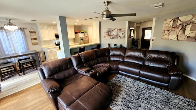 18534 Wolf Creek Trl, Humble, TX 77346 - living area with light wood finished floors, ceiling fan, and recessed lighting