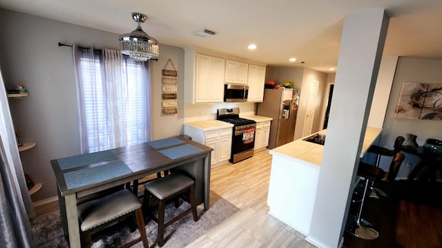 18534 Wolf Creek Trl, Humble, TX 77346 - kitchen featuring stainless steel appliances, white cabinetry, recessed lighting, a chandelier, and a peninsula