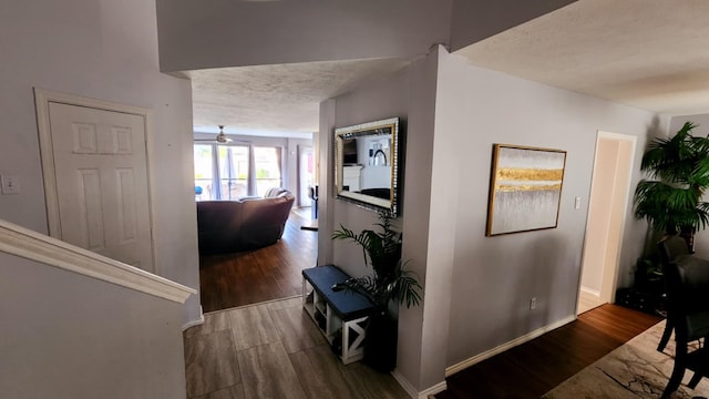 18534 Wolf Creek Trl, Humble, TX 77346 - hallway featuring wood finished floors, a textured ceiling, and baseboards