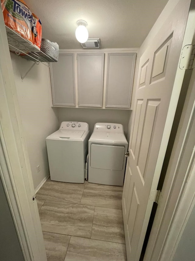 18534 Wolf Creek Trl, Humble, TX 77346 - laundry area with cabinet space, washer and clothes dryer, and light wood-style floors
