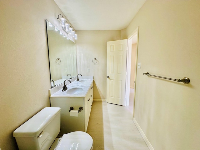 4142 Surreydon Dr, Houston, TX 77014 - bathroom with toilet, baseboards, double vanity, and wood finished floors