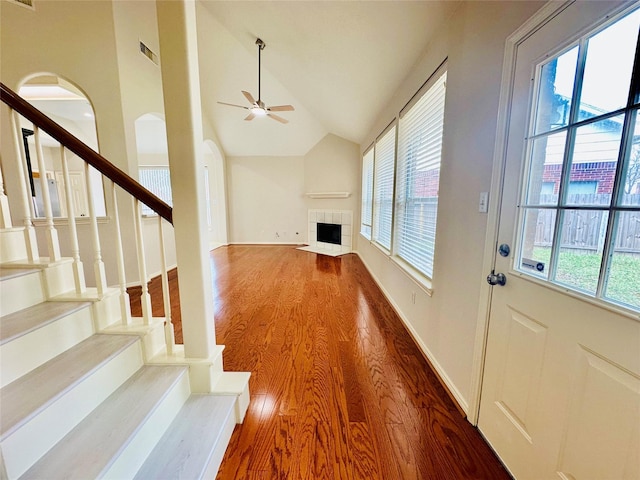 4142 Surreydon Dr, Houston, TX 77014 - unfurnished living room with wood finished floors, vaulted ceiling, a ceiling fan, a tiled fireplace, and stairs