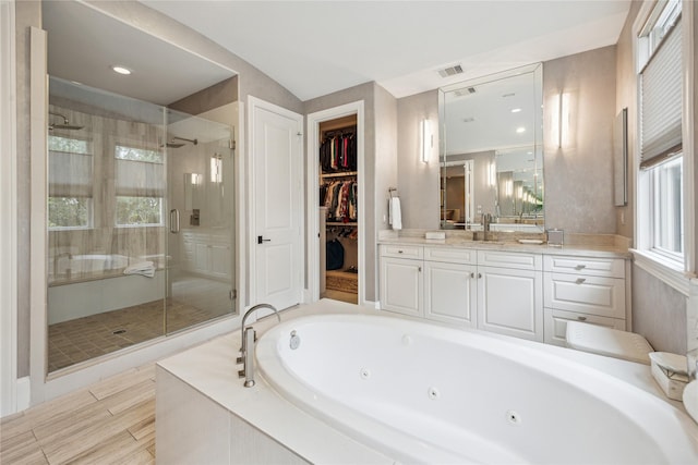 bathroom featuring a stall shower, a jetted tub, and healthy amount of natural light