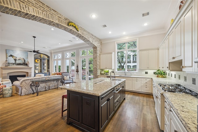 kitchen with ornamental molding, a breakfast bar, open floor plan, dark wood-style flooring, and backsplash