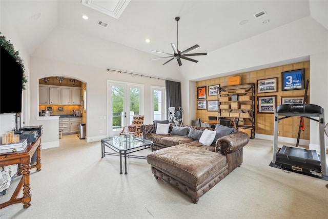 living area with light colored carpet, ceiling fan, vaulted ceiling, french doors, and baseboards