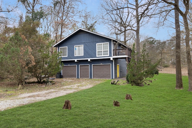 view of side of property with dirt driveway, a yard, and a garage