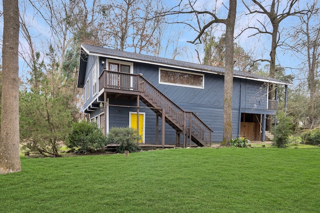 rear view of house featuring stairs, a yard, and a deck