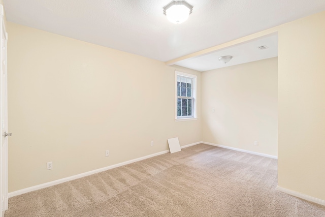 unfurnished room with light carpet and baseboards