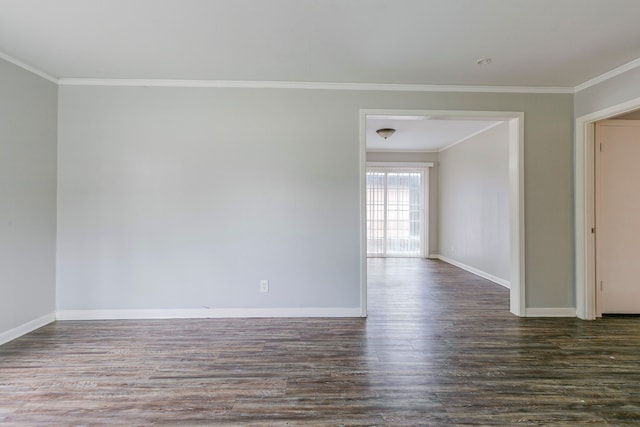 spare room featuring crown molding, dark wood-style flooring, and baseboards