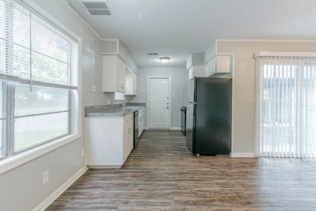 kitchen featuring freestanding refrigerator, a sink, baseboards, white cabinetry, and dishwashing machine
