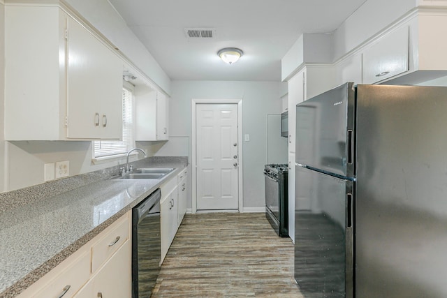 kitchen with black appliances, a sink, wood finished floors, and white cabinets